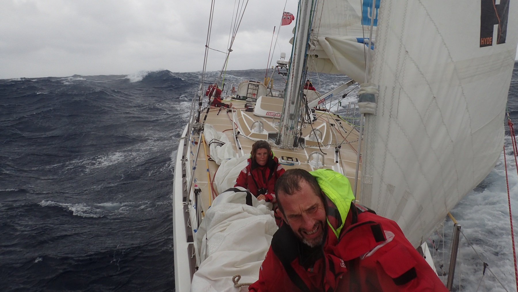 Crew members pictured on deck during stormy conditions 