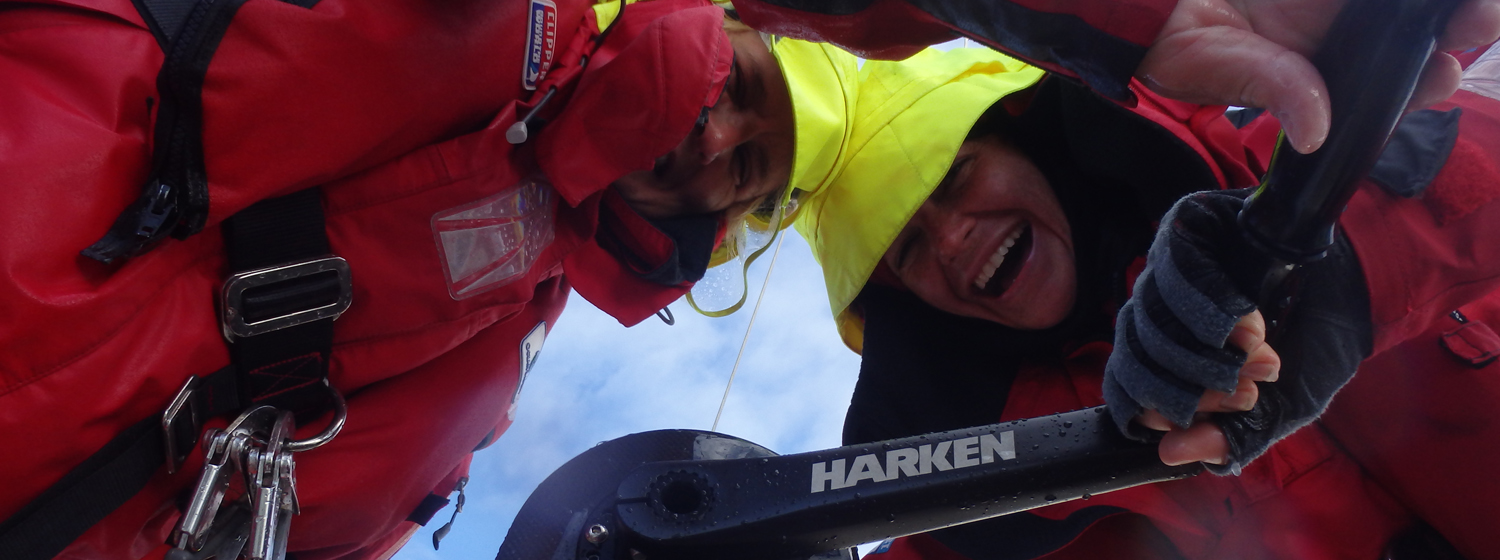 Two crew members using a Harken grinder onboard during the last race