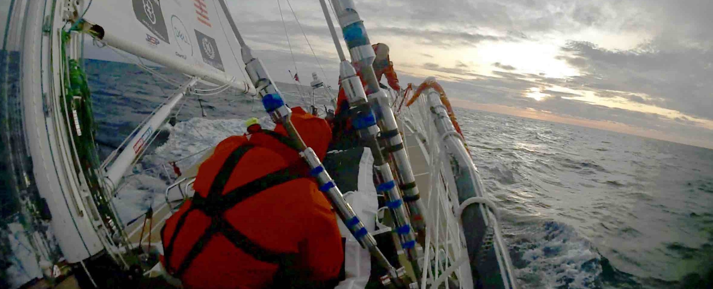 Sanya Serenity Coast crew moving sail bag as yacht is heeled over