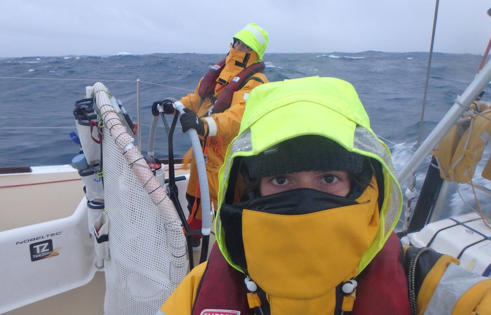Crew member looking into camera in full foulies with just eyes showing
