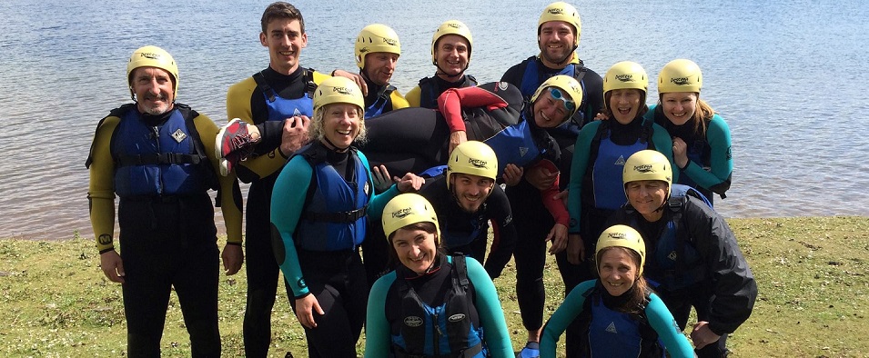 Skipper Wendo shown being raised by her team after a raft building challenge in the Peak District 