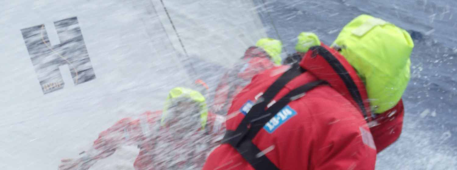 Picture of crew in tough weather conditions on the last Clipper Race, with Hyde Sails logo. 