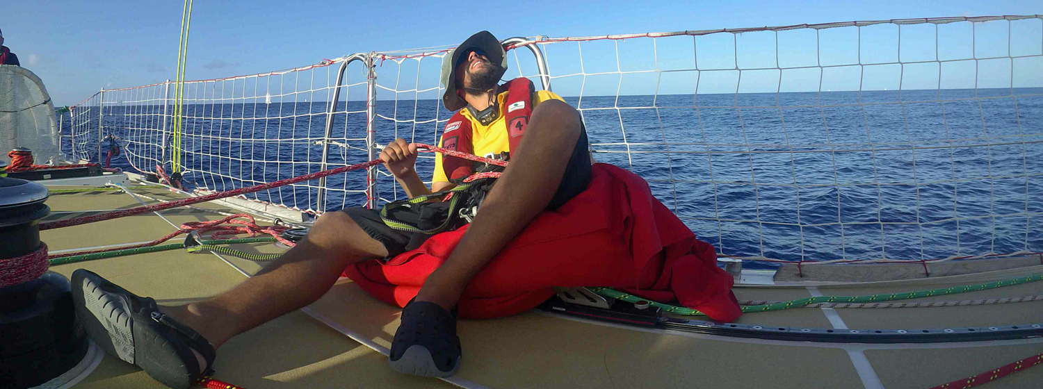 Qingdao crew member Greg Schey trims the sails in light winds