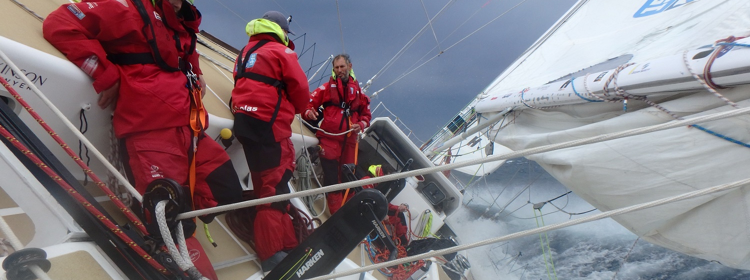 Crew shown standing at an angle in rough weather as Pacific Ocean front takes force 